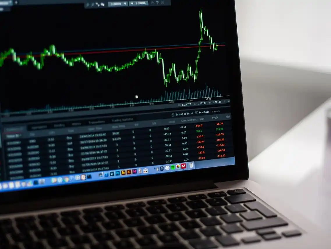 Laptop computer screen with a line graph and numbers in red and green below.