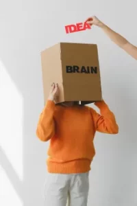 Woman with Box over her head. Hand putting idea in box.