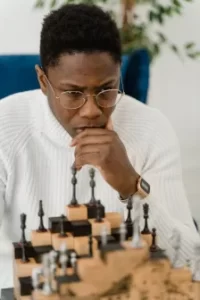 Young man studying chessboard.